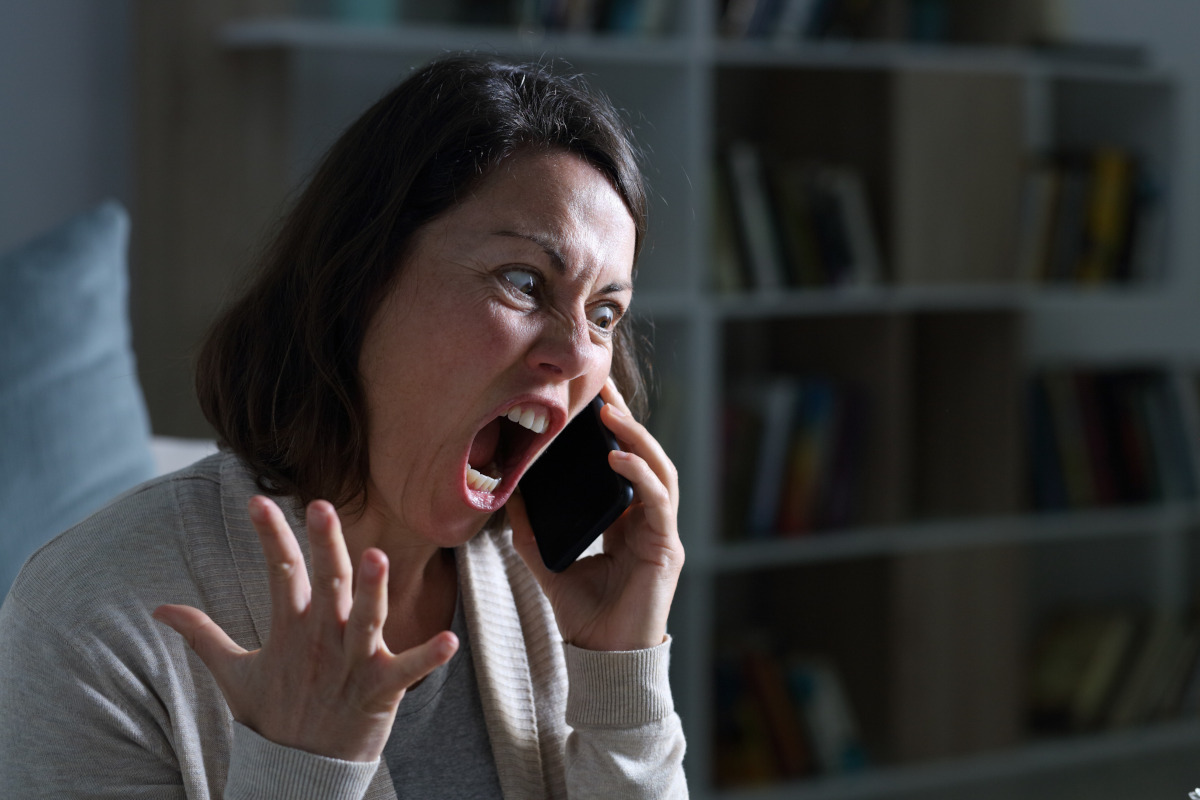 Adult woman screaming on phone.