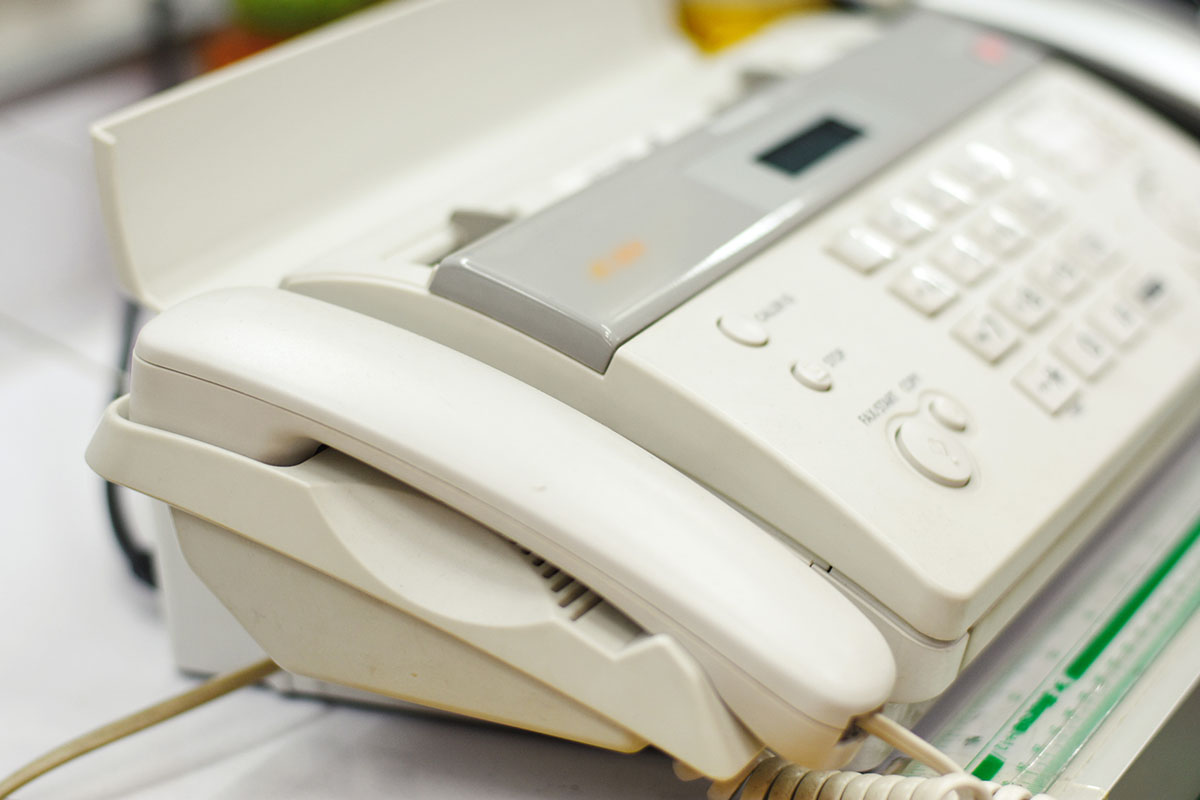 Close up image of old fax machine on desktop.
